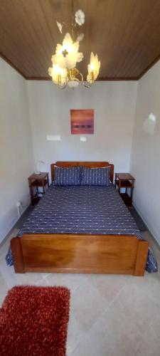 a bedroom with a large wooden bed in a room at Cantinho da Avó in Vila do Bispo