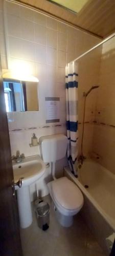 a bathroom with a toilet and a sink and a tub at Cantinho da Avó in Vila do Bispo