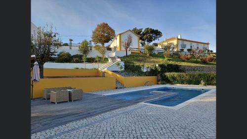 a swimming pool in a yard with a house at QUINTA DE SANT'ANA in Redinha