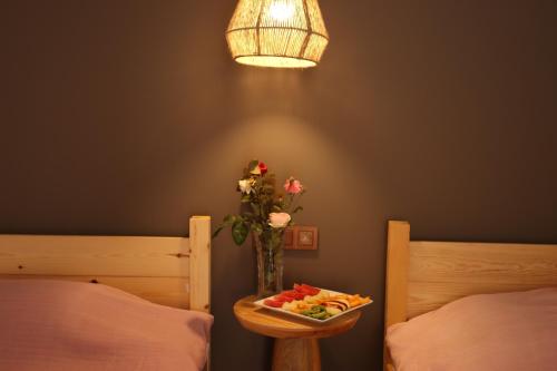 a table with a plate of fruit and a vase of flowers at Dalya Life in Göcek