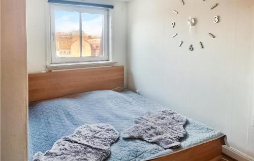 a bedroom with a bed and a clock on the wall at Amazing Apartment In Ystad With 1 Bedrooms in Ystad