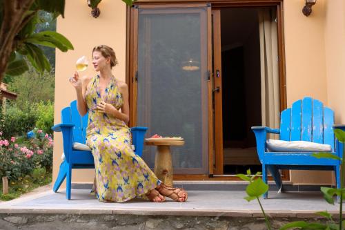 a woman in a dress sitting on two chairs eating a drink at Dalya Life in Göcek