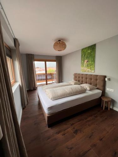 Un dormitorio con una cama grande y una ventana en Chic lodge-apartments, en Ehrwald