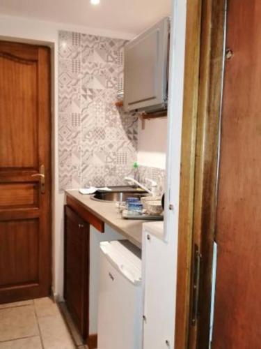 une petite cuisine avec un évier et un réfrigérateur dans l'établissement Mont Blanc - locations de charme, à Beaurainville