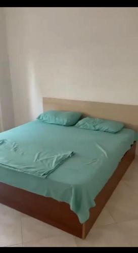 uma cama com lençóis azuis e almofadas azuis em Sunset Apartment em Durrës