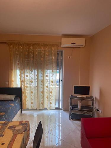 uma sala de estar com um sofá e uma televisão em Sunset Apartment em Durrës