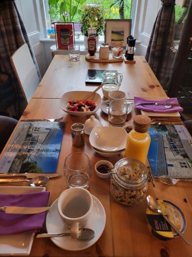 una mesa de madera con platos de comida. en Scooniehill Farm House B&B en St Andrews