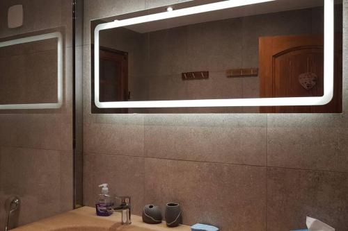 een badkamer met een wastafel en een grote spiegel bij Mon refuge face au Mont Blanc in Saint-Gervais-les-Bains