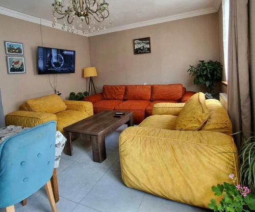 a living room with two couches and a table at North Kazbegi in Stepantsminda