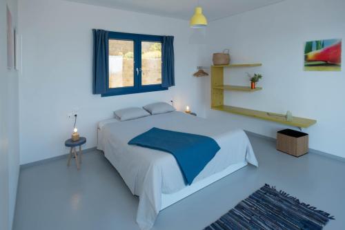 - une chambre bleue avec un lit et une fenêtre dans l'établissement Elpida - breathtaking view, à Mochlos