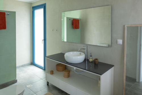 a bathroom with a sink and a mirror at Elpida - breathtaking view in Mochlos
