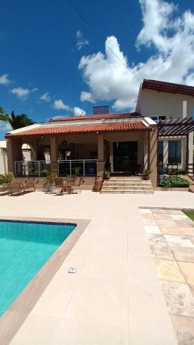 uma villa com uma piscina e uma casa em Pousada Brisa do Mar em Aquiraz