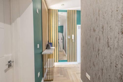 a hallway with a mirror and green walls at The Pocklington - The Golden Mile Suite in Leicester