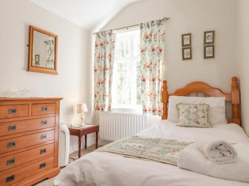 a bedroom with a bed and a dresser and a window at High Stile in Keswick