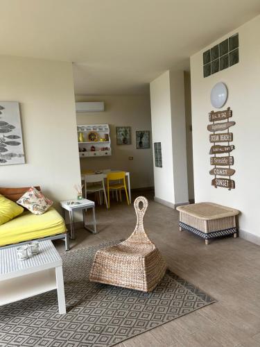 a living room with a yellow couch and chairs at TERRATETTO SUNSET in Capoliveri