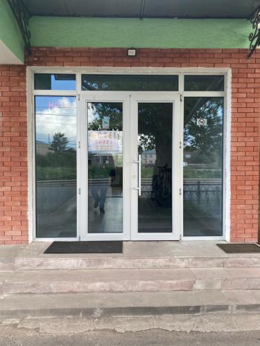 a glass door of a building with a person inside at Hotel Sharl in Ninotsminda