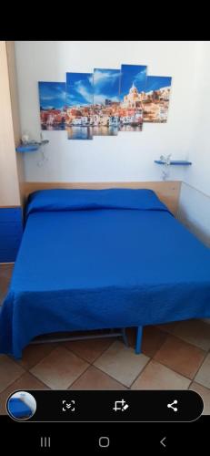 a bedroom with a blue bed with a remote control at il colibri' in Procida