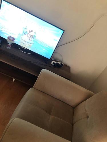 een woonkamer met een bank en een flatscreen-tv bij Coolest Appartement 2+1 Furnished in Istanbul