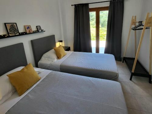 a bedroom with two beds and a window with a door at Omikron in Mikro