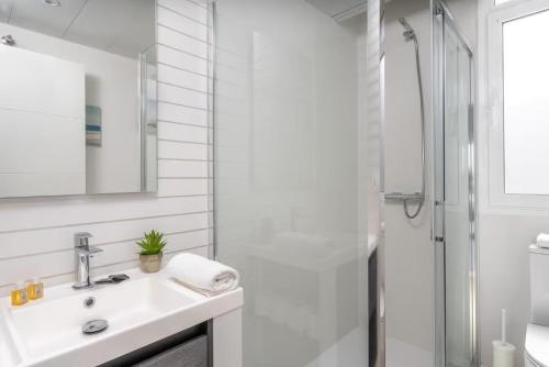 a white bathroom with a sink and a shower at Penthouse Banderas with own pool in La Cala de Mijas