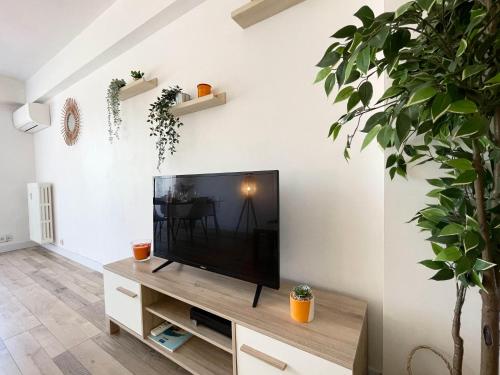 a living room with a flat screen tv on a stand at Comfortable apartment with parking - Antibes Riviera in Antibes