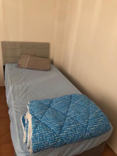 een bed met een blauw dekbed en een kussen bij Coolest Appartement 2+1 Furnished in Istanbul