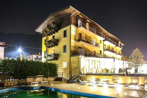 un bâtiment avec une piscine en face d'un bâtiment dans l'établissement Albergo Mezzolago, à Mezzolago