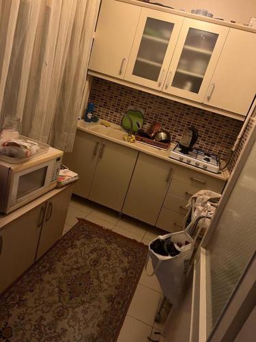 een kleine keuken met een magnetron en een wastafel bij Coolest Appartement 2+1 Furnished in Istanbul