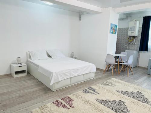 una camera bianca con letto, tavolo e sedie di DXN Luxury Studio 3 a Năvodari