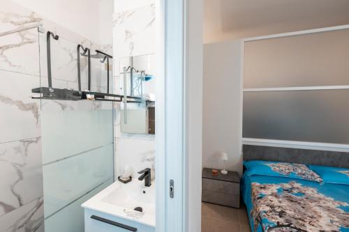 baño con cama y lavamanos en LA MANDORLA Luxury Rooms en Caltabellotta