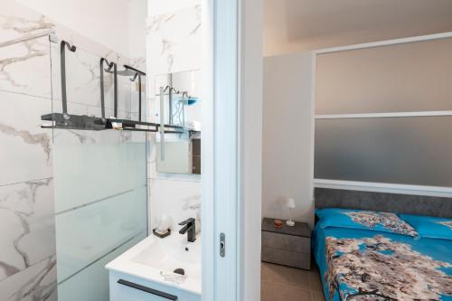 a bathroom with a bed and a sink at LA MANDORLA Luxury Rooms in Caltabellotta