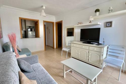 salon z kanapą i telewizorem z płaskim ekranem w obiekcie Buena vista, apartamento en la playa Finestrat w mieście Cala de Finestrat