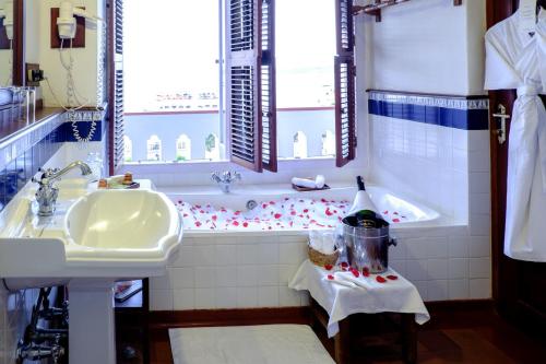 a bathroom with a bath tub and a sink at Brunton Boatyard - CGH Earth in Cochin