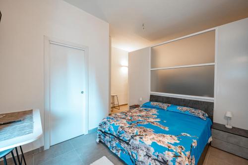 a bedroom with a bed with a blue comforter at LA MANDORLA Luxury Rooms in Caltabellotta