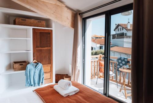 ビアリッツにあるBiarritz Surf Lodge Chambre d'hôtesのベッドルーム1室(バルコニーの景色を望む窓付)