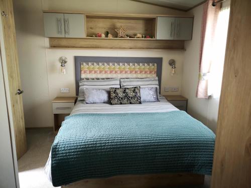 1 dormitorio con 1 cama grande en una habitación en Lake Escape - Hoburne Cotswolds, en South Cerney