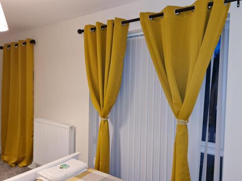 a room with yellow curtains on a wall at Mills Home Stays in Derby