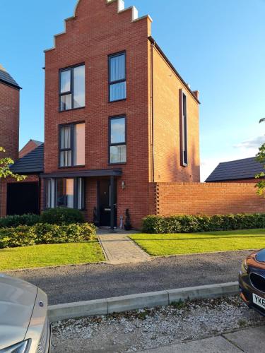 a brick house with a car parked in front of it at Mills Home Stays in Derby