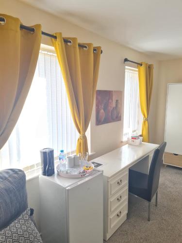 a room with a desk and a bed and curtains at Mills Home Stays in Derby