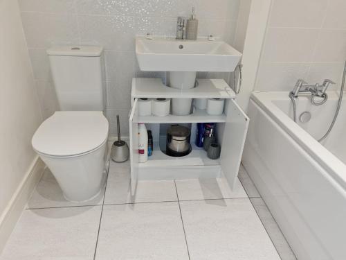 La salle de bains est pourvue d'un lavabo, de toilettes et d'une baignoire. dans l'établissement Mills Home Stays, à Derby