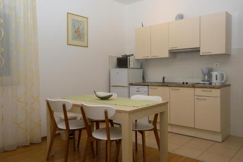 cocina con mesa, sillas y barra en Apartments Stipe Plazibat, en Hvar