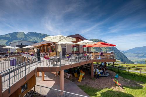 a building with tables and umbrellas and a playground at The Swiss Paradise 1 Penthouse apartment in Wirzweli