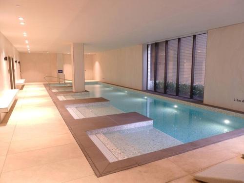 a large swimming pool with a row of windows at Caulfield Village Apartment in Melbourne