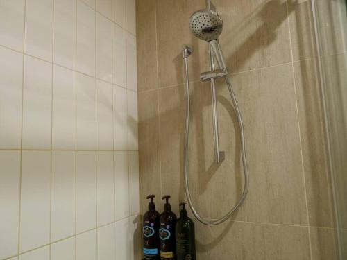 a shower with a shower head in a bathroom at Caulfield Village Apartment in Melbourne