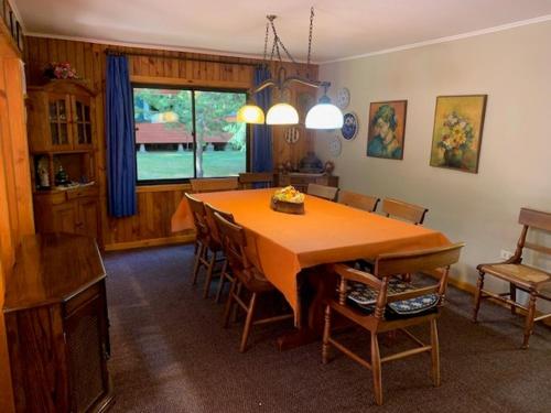 uma sala de jantar com uma grande mesa de madeira e cadeiras em Cabaña en Termas de Chillán em Pinto