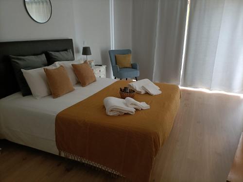 a bedroom with a bed with two towels on it at Casa da Padaria in Folgosa