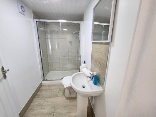 a white bathroom with a sink and a shower at Solihull Shared House in Birmingham