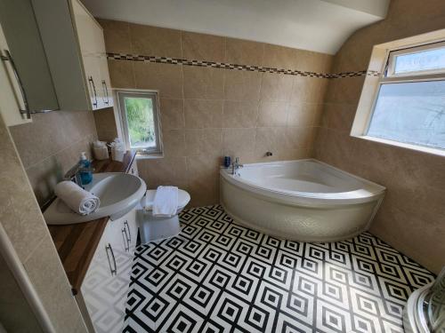 a bathroom with a tub and a sink at Solihull Shared House in Birmingham