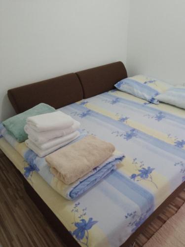 a bed with blue and white sheets and towels on it at APARTMAN BUKULJA 2 in Arandelovac