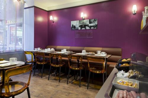 a dining room with purple walls and tables and chairs at Timhotel Paris du Gare du Nord in Paris